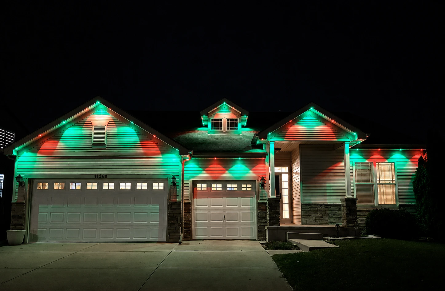 Home rooflines illuminated with red and green seasonal lighting at night